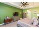 Comfortable bedroom features a tray ceiling, ceiling fan, and a door to an ensuite at 4920 Sevilla Shores Dr, Wimauma, FL 33598