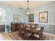 Charming dining room with a large wooden table, setting for six, and a stylish chandelier at 4920 Sevilla Shores Dr, Wimauma, FL 33598