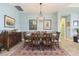 Elegant dining room featuring a wooden table with seating for six under a modern light at 4920 Sevilla Shores Dr, Wimauma, FL 33598