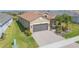Inviting home exterior featuring a two-car garage, brick driveway, and well-kept landscaping at 4920 Sevilla Shores Dr, Wimauma, FL 33598