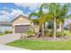 Inviting one-story home with lush tropical landscaping, brick driveway, and a neutral color scheme at 4920 Sevilla Shores Dr, Wimauma, FL 33598