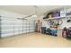 Spacious garage with epoxy flooring and overhead storage racks at 4920 Sevilla Shores Dr, Wimauma, FL 33598