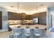 Spacious kitchen featuring a large island with bar seating and modern dark wood cabinets with stainless steel appliances at 4920 Sevilla Shores Dr, Wimauma, FL 33598