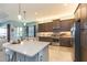 Bright kitchen featuring stainless steel appliances, dark wood cabinetry, and a large center island with seating at 4920 Sevilla Shores Dr, Wimauma, FL 33598