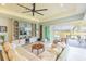 Living room featuring comfortable sofa, large entertainment center, and sliding glass doors with water views at 4920 Sevilla Shores Dr, Wimauma, FL 33598