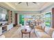 Spacious living room with a large television, comfortable seating, and sliding glass doors that open to a patio at 4920 Sevilla Shores Dr, Wimauma, FL 33598