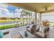 Relaxing screened patio with a view of the lake, palm trees, and well-manicured lawn at 4920 Sevilla Shores Dr, Wimauma, FL 33598