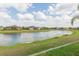 Scenic view of a pond surrounded by lush green grass and several homes in the background at 4920 Sevilla Shores Dr, Wimauma, FL 33598