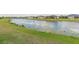 Serene pond landscape with a backdrop of well-maintained lawns and residential properties at 4920 Sevilla Shores Dr, Wimauma, FL 33598