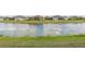 Tranquil pond view showcasing the water feature bordered by green grass and neighboring residences at 4920 Sevilla Shores Dr, Wimauma, FL 33598