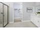 Modern bathroom featuring a glass-enclosed shower, double vanity, and a walk-in closet at 5020 124Th E Ave, Parrish, FL 34219