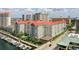 This aerial shows a grey multi-story complex with a red tile roof, a pool and landscaping on a sunny day with urban views at 700 S Harbour Island Blvd # 735, Tampa, FL 33602