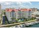 An aerial view showcases waterfront condos with a pool, marina, boat docks and palm trees with nearby buildings in the background at 700 S Harbour Island Blvd # 735, Tampa, FL 33602
