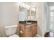 A bathroom featuring a vanity with dark granite counters, a framed mirror and a toilet at 700 S Harbour Island Blvd # 735, Tampa, FL 33602