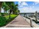 A brick walkway lined with lush greenery and palm trees, leading to a marina with boats on the water at 700 S Harbour Island Blvd # 735, Tampa, FL 33602