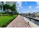 Scenic view of a marina's walkway lined with lush greenery leading towards docked boats, against a bright blue sky at 700 S Harbour Island Blvd # 735, Tampa, FL 33602