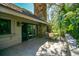 Back deck with a stone chimney in a lush, green, wooded backyard at 707 Old Mill Pond Rd, Palm Harbor, FL 34683