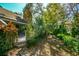 Lush backyard landscaping with mature trees, providing shade and privacy with a stone chimney at 707 Old Mill Pond Rd, Palm Harbor, FL 34683
