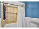 A view of the bathtub and shower area with a tiled surround and shower curtain at 707 Old Mill Pond Rd, Palm Harbor, FL 34683