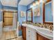 Bright bathroom features double sink vanity with tile accents, and a bathtub with tile surround at 707 Old Mill Pond Rd, Palm Harbor, FL 34683