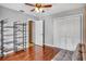 Spacious bedroom with wood floors, shelving, ceiling fan and convenient access to the bathroom at 707 Old Mill Pond Rd, Palm Harbor, FL 34683