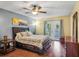 Comfortable bedroom with wood floors, ceiling fan, and direct access to the outdoor balcony at 707 Old Mill Pond Rd, Palm Harbor, FL 34683