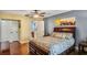 Relaxing bedroom showcasing wood floors, ceiling fan, and connecting door to the en-suite bathroom at 707 Old Mill Pond Rd, Palm Harbor, FL 34683