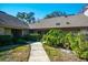Charming exterior view showcasing the home's landscaping and well-lit walkway at 707 Old Mill Pond Rd, Palm Harbor, FL 34683