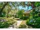 Inviting front yard landscape with mature trees and a sidewalk leading to the house at 707 Old Mill Pond Rd, Palm Harbor, FL 34683