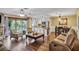 Open-concept living room with wood floors, neutral decor, and access to a balcony at 707 Old Mill Pond Rd, Palm Harbor, FL 34683