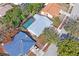 Property's surroundings, including mature trees, neighboring houses, and a private screened pool at 8204 Reynolds Dr, Hudson, FL 34667