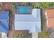 Aerial view of a screened pool and backyard with a well-maintained light gray shingle roof on a sunny day at 8204 Reynolds Dr, Hudson, FL 34667