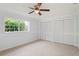 This spacious bedroom features neutral carpet, a ceiling fan and large closets at 8204 Reynolds Dr, Hudson, FL 34667