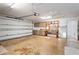 Spacious garage features concrete floors, work bench, shelving, ceiling fan and door to the house at 8204 Reynolds Dr, Hudson, FL 34667
