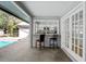 Outdoor seating area next to pool, including chairs and pass through to kitchen at 8204 Reynolds Dr, Hudson, FL 34667