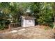 Charming shed with a cute window and a small porch, surrounded by lush greenery and mature trees at 8204 Reynolds Dr, Hudson, FL 34667