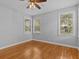 Sun-filled bedroom with hardwood floors, a ceiling fan, and three windows offering neighborhood views at 914 S Bruce St, Tampa, FL 33606