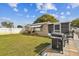 Backyard of single-story house showing the lawn, garden, patio and grill at 9201 Lunar Ln, Port Richey, FL 34668