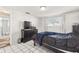 Relaxing bedroom features a queen bed, TV on a dresser, window, and tile floors for a simple design at 9201 Lunar Ln, Port Richey, FL 34668
