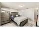 Well-lit bedroom showcases a queen bed, complementing dressers, mirrored accents, and white tile floors at 9201 Lunar Ln, Port Richey, FL 34668