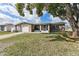 Charming home featuring a paved driveway, well-maintained lawn and mature tree providing nice curb appeal at 9201 Lunar Ln, Port Richey, FL 34668
