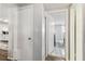 Hallway view showcasing entry to a bedroom, featuring white doors and tiled floors for a seamless transition at 9201 Lunar Ln, Port Richey, FL 34668