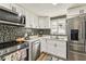 Bright kitchen with stainless appliances, stylish backsplash, and abundant counter space at 9201 Lunar Ln, Port Richey, FL 34668