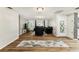 Open-concept living room featuring wood flooring, dark velvet furniture, and stylish light fixtures at 9201 Lunar Ln, Port Richey, FL 34668