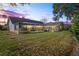 Twilight view of a home backyard, featuring an enclosed porch and lush lawn at 9405 Ashley Dr, Weeki Wachee, FL 34613
