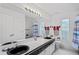 Well-lit bathroom with a double sink vanity, a toilet, and a shower with a curtain at 9405 Ashley Dr, Weeki Wachee, FL 34613