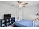 Well-lit bedroom with a ceiling fan, a television, and comfortable furnishings at 9405 Ashley Dr, Weeki Wachee, FL 34613
