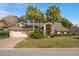 Charming home featuring palm trees, well-manicured landscaping, and a two-car garage at 9405 Ashley Dr, Weeki Wachee, FL 34613