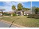 Charming one-story home featuring a well-manicured lawn and mature palm trees at 9405 Ashley Dr, Weeki Wachee, FL 34613