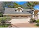Two car garage provides ample parking and storage space, complemented by a tidy front yard and attractive facade at 9405 Ashley Dr, Weeki Wachee, FL 34613